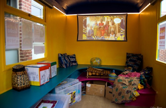 Stedenbandhuisje: Kleurrijke lees- en speelruimte met kussens, Afrikaanse decoraties en een projectiescherm. (vergroot foto)