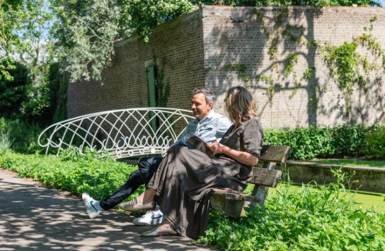 Twee mensen zitten op een bankje in het Kaandelpark. (vergroot foto)